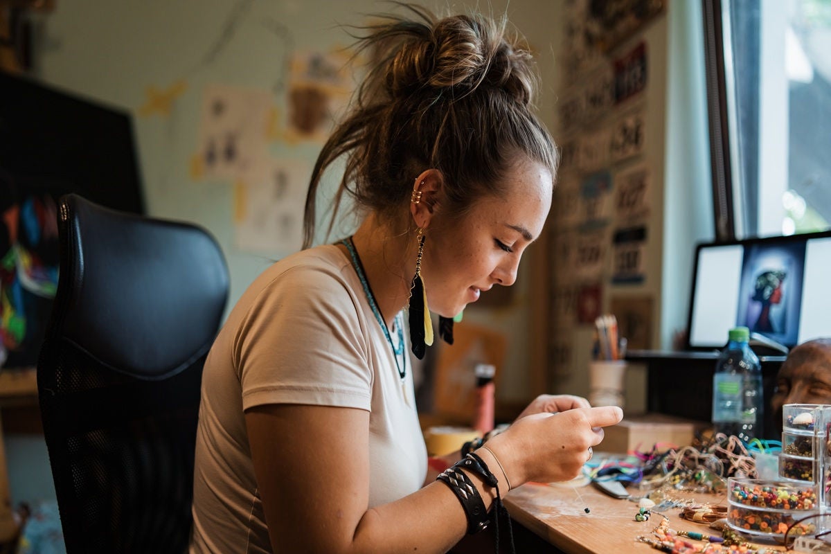 Small business owner creating handmade jewelry indoors